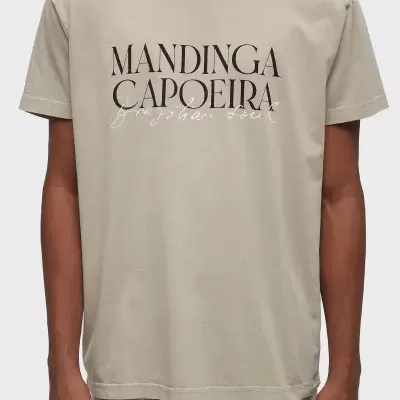 T-shirt bege com texto 'MANDINGA CAPOEIRA' na frente.