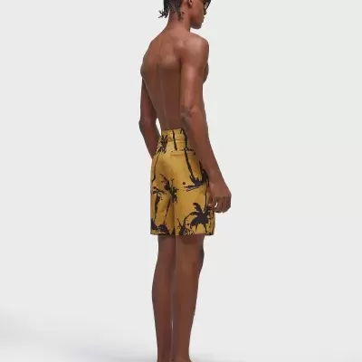 Calções de banho amarelos com padrão tropical preto usados por modelo de perfil