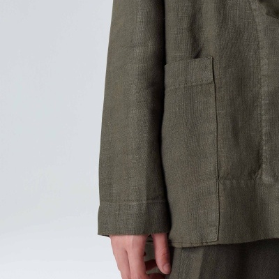 Detalhe lateral de roupa verde-oliva com bolso e manga comprida