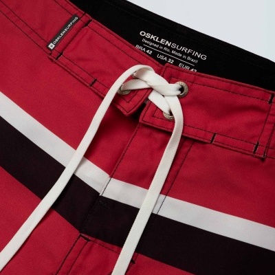 Calções de banho vermelhos com faixas e cordão branco, etiqueta interna visível.