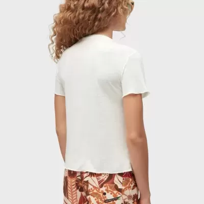 Pessoa de costas com t-shirt branca e calções florais castanhos e laranja.