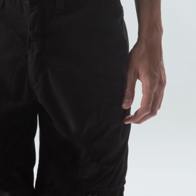 Bermuda preta masculina com bolso lateral e ilhóses metálicos.