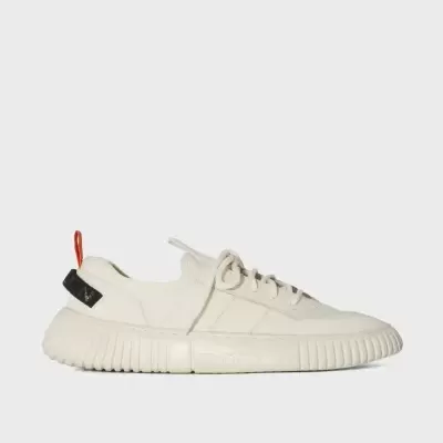 Sapatilha branca em perfil sobre fundo cinzento claro