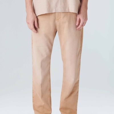 Calças bege com efeito degradé, sapatos abertos claros e camisa bege com botões sobre fundo neutro