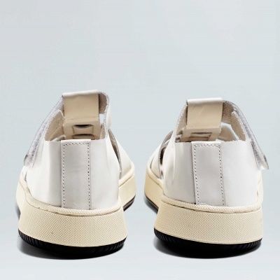 Par de sapatilhas brancas com sola bege vista de trás