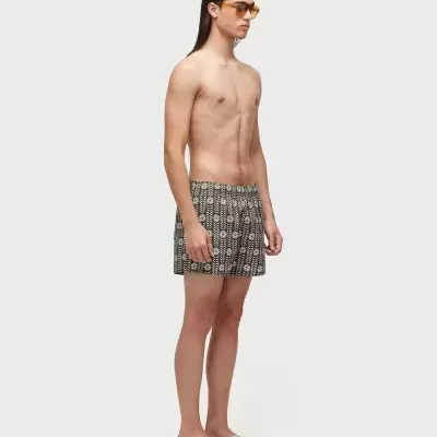 Modelo masculino com calções de banho com padrão floral em fundo branco