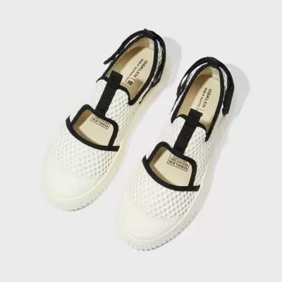 Sapatilhas brancas com detalhes pretos e sola branca em fundo branco