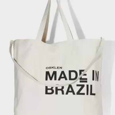 Bolsa de tecido creme com texto preto 'OSKLEN MADE IN BRAZIL'