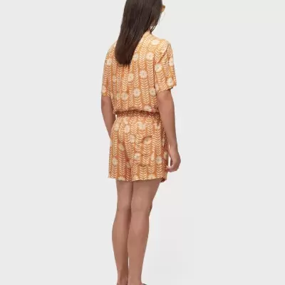 Pessoa de costas com fato de banho ou pijama floral laranja e branco e chinelos pretos.