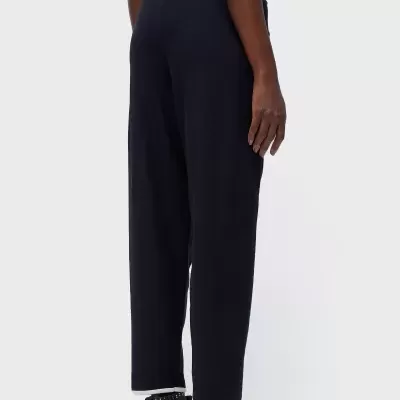 Calças pretas compridas de tecido liso com ténis pretos