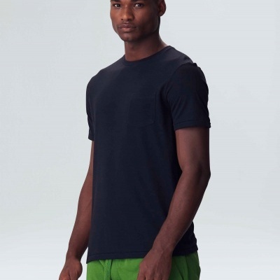 Homem a usar t-shirt preta e calças verdes com fundo branco