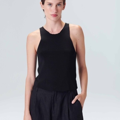 Mulher a usar top feminino preto canelado e calças largas pretas em fundo branco