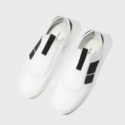 Sapatos brancos e pretos OSKLEN sobre fundo branco