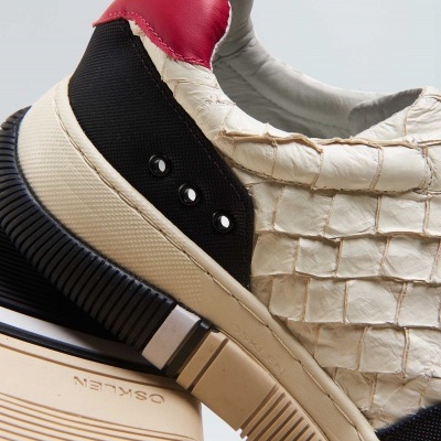 Ténis creme com padrão de pele, detalhes em preto e vermelho, sola bege e preta