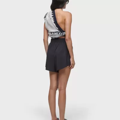 Mulher vista de costas com roupa de verão preta e branca e sandálias