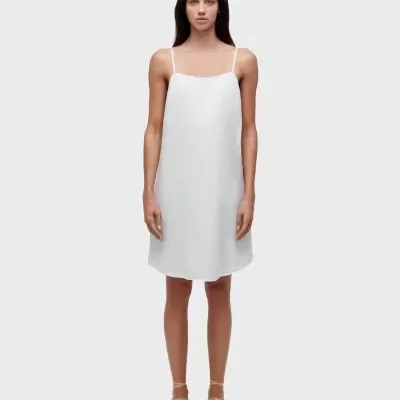 Vestido branco de alças finas em modelo com sapatos bege