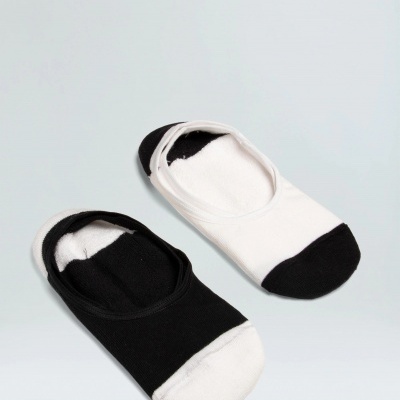 Par de meias rasas pretas e brancas com biqueiras contrastantes sobre fundo branco