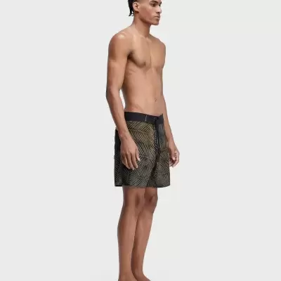 Homem com calções de banho verdes e pretos com padrão de folhas