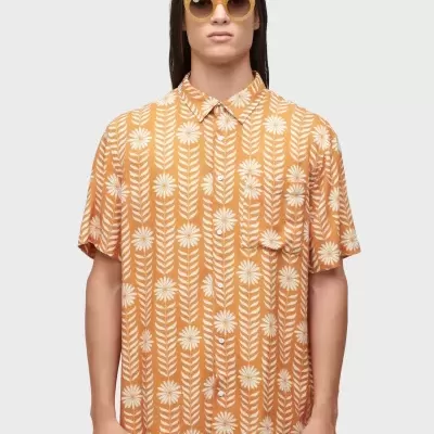 Camisola de manga curta laranja com padrão branco de flores e folhas e bolso no peito