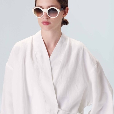 Mulher com óculos de sol brancos e casaco branco
