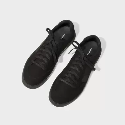 Sapatilhas pretas com atacadores em fundo branco