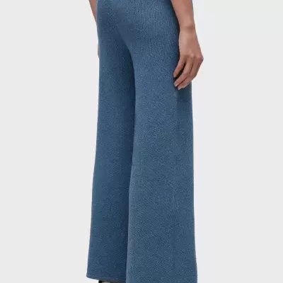 Calças largas azuis de tecido texturizado com sapatilhas brancas e camisola vermelha