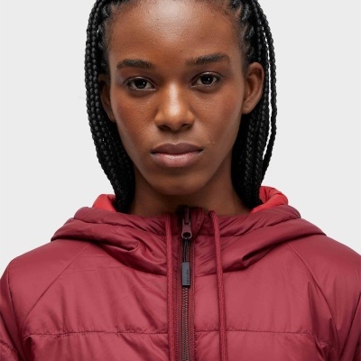 Mulher com casaco acolchoado bordeaux com capuz.