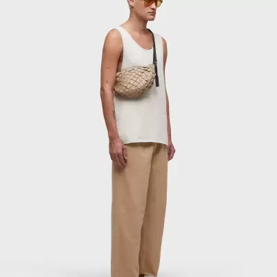 Homem de perfil com pochete bege e roupa casual