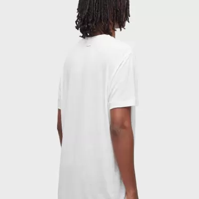 Pessoa de costas com t-shirt branca e cabelo rastafari.