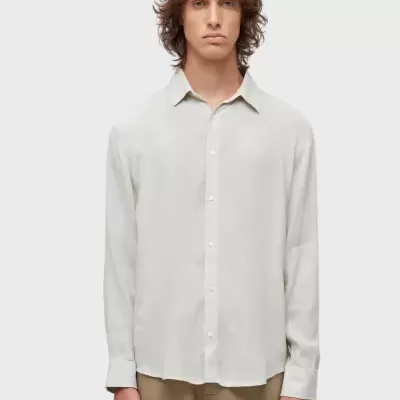 Camisa bege claro de tecido leve com botões brancos e calças castanhas claras