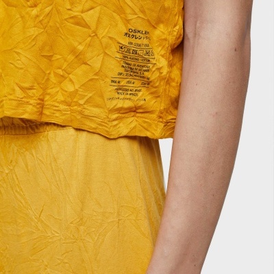 Roupa amarela com textura amassada e etiqueta interna visível