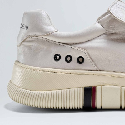 Tênis branco em pele com sola branca detalhada e ilhóses pretos