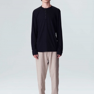 Homem com camisa preta de manga comprida e calças bege