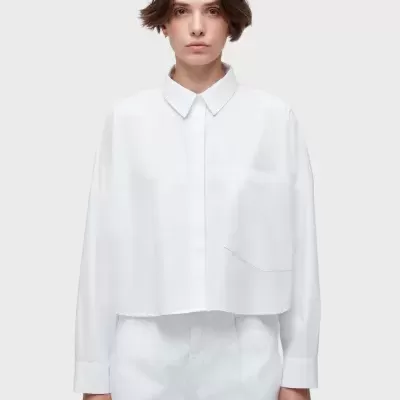 mulher vestindo camisa branca de manga comprida e calças brancas