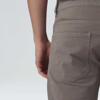 Parte traseira de calças cinza castanho e camisa verde em fundo branco