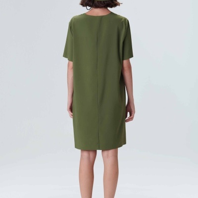 Vestido curto verde-oliva com chapéu e sapatos brancos visto pelas costas