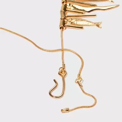 Colar dourado com pendentes em forma de peixes e anzóis sobre fundo branco