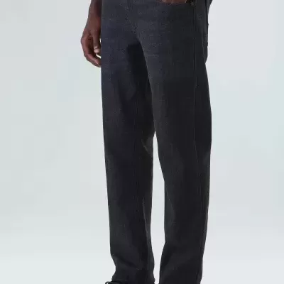 Pessoa com calças de ganga pretas e sapatos pretos com sola branca