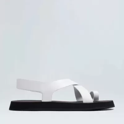 Sandália branca com tiras cruzadas e sola preta plana