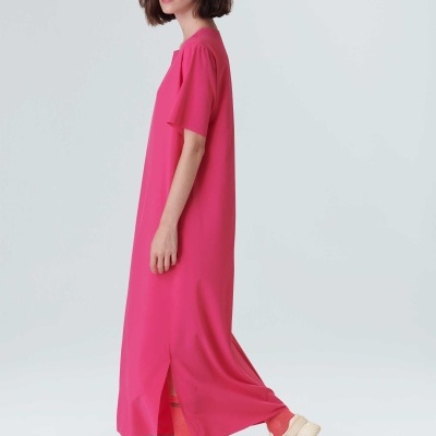 Vestido longo rosa com fenda lateral, leggings vermelhas e sandálias brancas