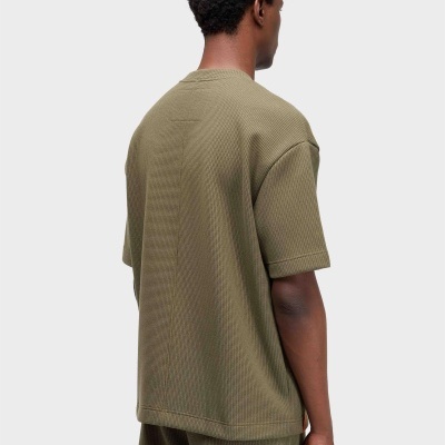 Homem com conjunto verde-oliva de t-shirt e calções, visto de costas