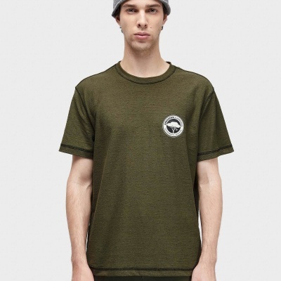 Homem com camisola verde escura com logótipo e gorro cinzento de malha