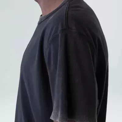 Camisola preta de manga curta com costuras visíveis e borda desfiada