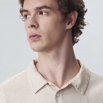 Camisa bege claro de homem com gola clássica e botões.