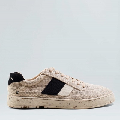 Ténis bege com detalhes pretos e sola bege com manchas.