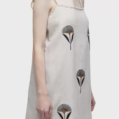 Vestido bege claro com flores estampadas pretas e amarelas num modelo