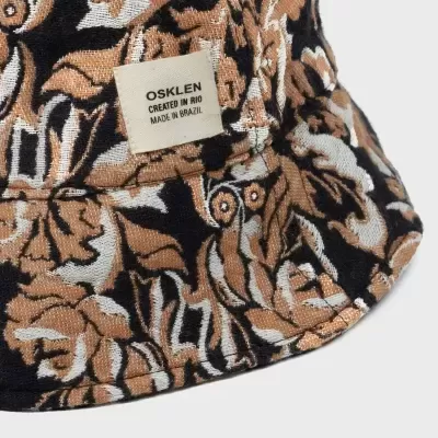 Chapéu com padrão floral castanho, branco e preto e etiqueta OSKLEN.