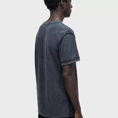 Homem de costas com t-shirt cinzento-escura e calças pretas