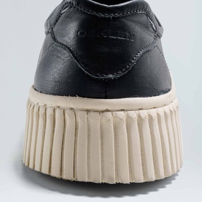 Sapato preto com sola alta creme visto de trás