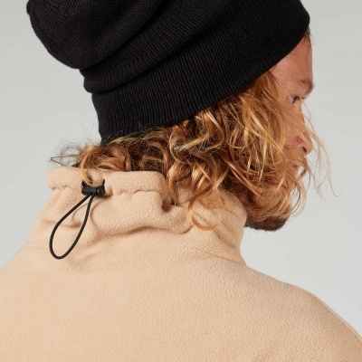 Pessoa de costas com gorro preto e casaco polar bege